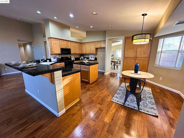 kitchen with pendant lighting, sink, dark wood-type flooring, black appliances, and kitchen peninsula