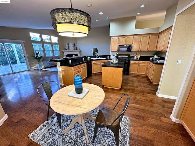 kitchen featuring decorative light fixtures, black appliances, a center island, kitchen peninsula, and dark wood-type flooring