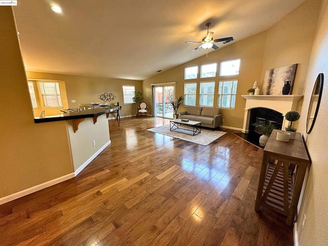 living room featuring ceiling fan, lofted ceiling, and dark hardwood / wood-style flooring