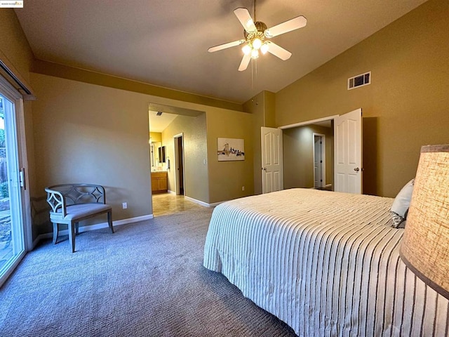 bedroom featuring ceiling fan, light colored carpet, ensuite bathroom, and vaulted ceiling