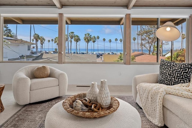 interior space featuring a water view, beam ceiling, and carpet floors