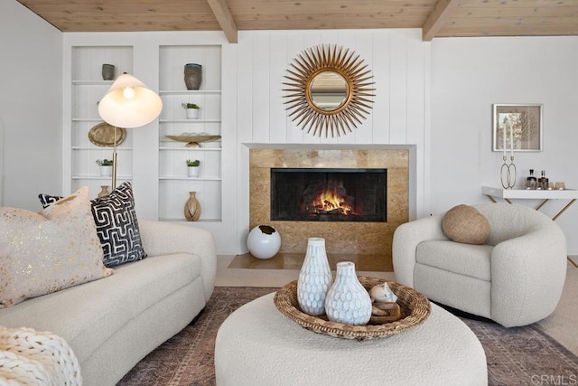 living room featuring beam ceiling, wood ceiling, and a fireplace