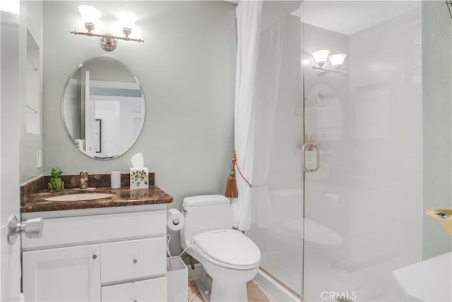 bathroom with an enclosed shower, vanity, and toilet