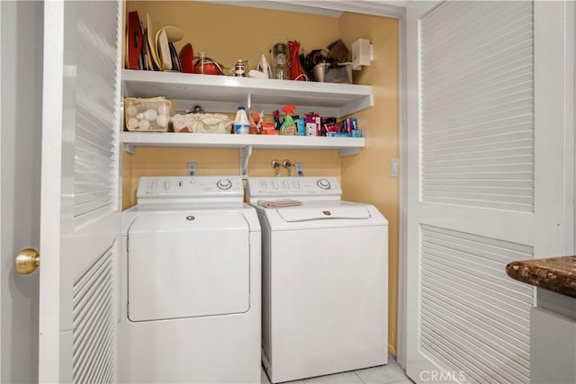 clothes washing area featuring washer and dryer and light tile patterned floors