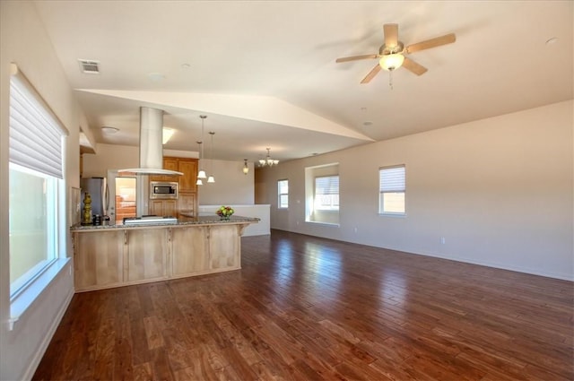 kitchen with ceiling fan with notable chandelier, island range hood, dark hardwood / wood-style flooring, stainless steel appliances, and light brown cabinets