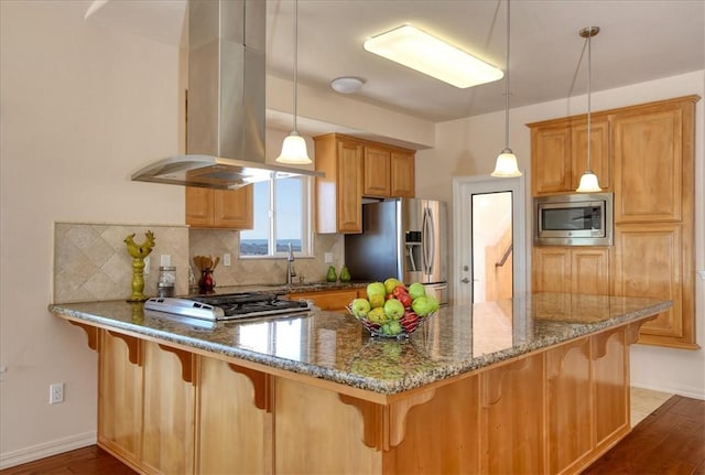 kitchen with island range hood, decorative light fixtures, appliances with stainless steel finishes, dark stone counters, and decorative backsplash