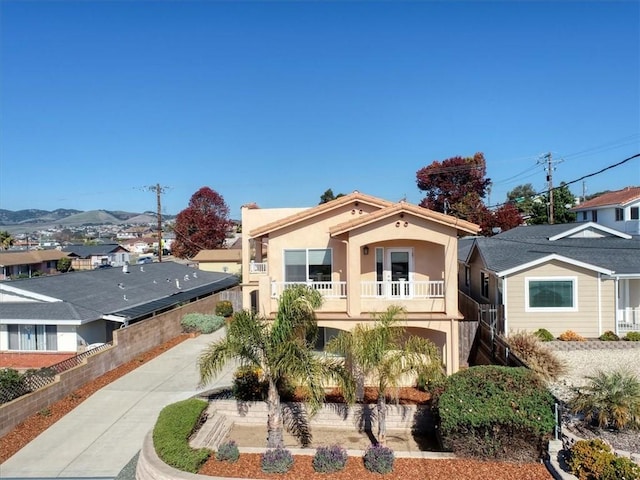 view of front of house with a balcony and a mountain view