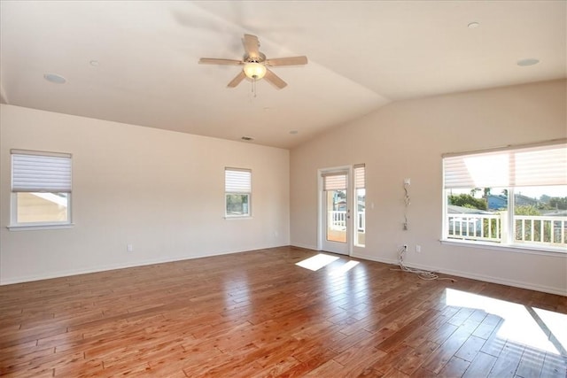 unfurnished room with ceiling fan, lofted ceiling, a wealth of natural light, and light wood-type flooring