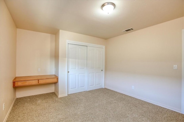 unfurnished bedroom with carpet flooring and a closet