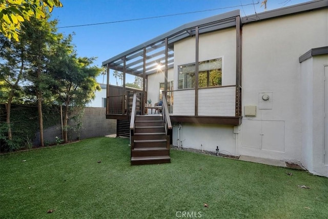 back of house featuring a wooden deck and a lawn