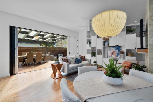 living room with ceiling fan and light hardwood / wood-style flooring