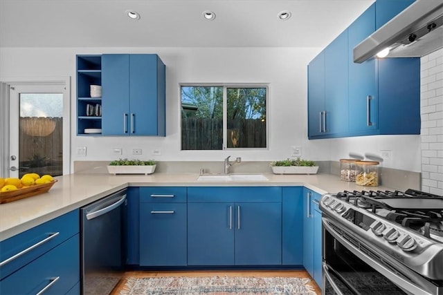 kitchen with extractor fan, blue cabinetry, sink, and appliances with stainless steel finishes