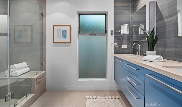 bathroom with a shower with door, vanity, and backsplash