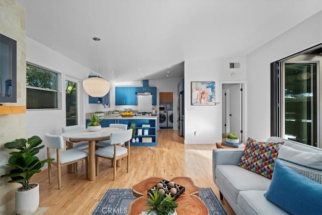 living room with washer and dryer and light hardwood / wood-style flooring