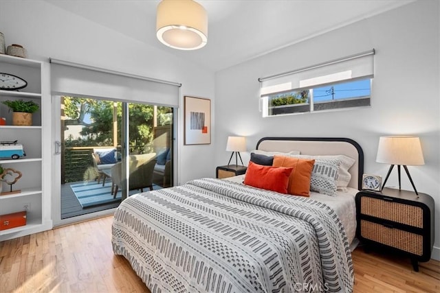 bedroom with lofted ceiling, access to exterior, and light hardwood / wood-style floors