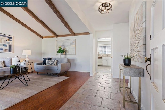 interior space with vaulted ceiling with beams and light hardwood / wood-style flooring