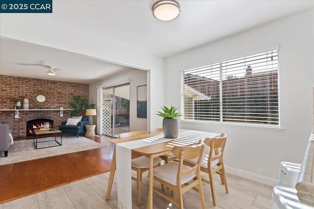 dining room with a brick fireplace and light hardwood / wood-style flooring