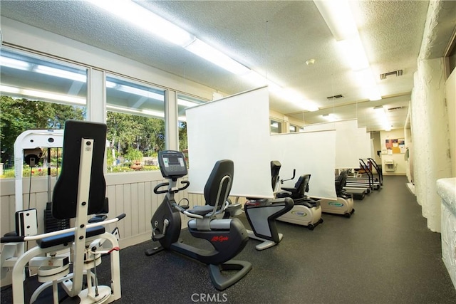 gym with visible vents and a textured ceiling