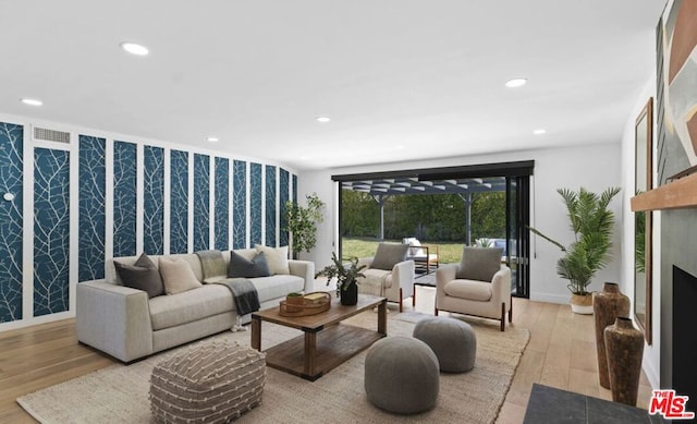 living room featuring a fireplace and light wood-type flooring