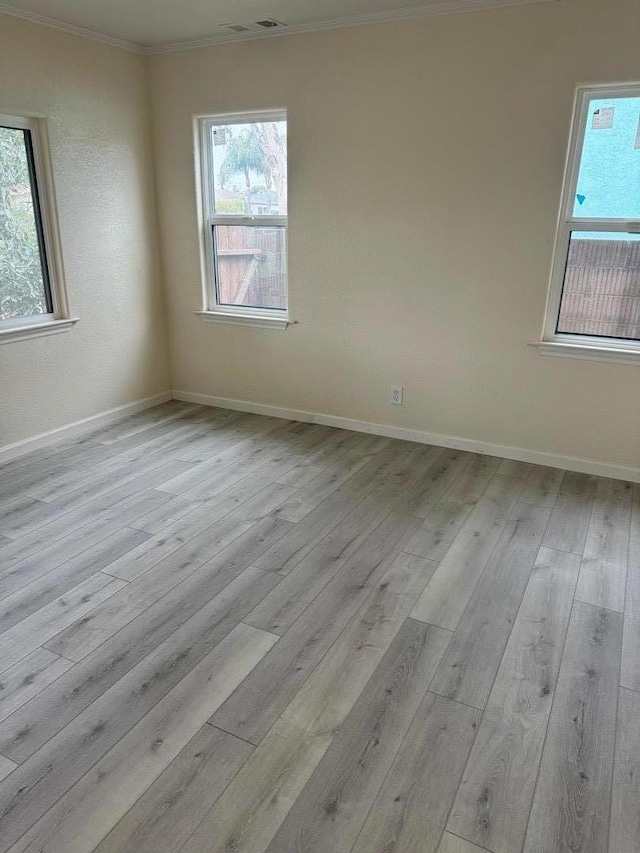 unfurnished room featuring crown molding and light hardwood / wood-style flooring