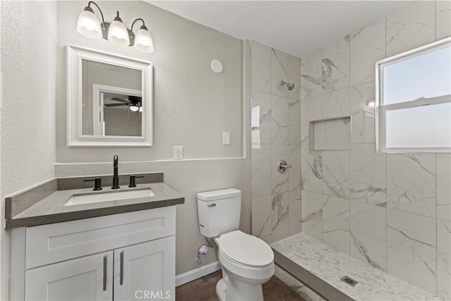 bathroom featuring vanity, toilet, and tiled shower