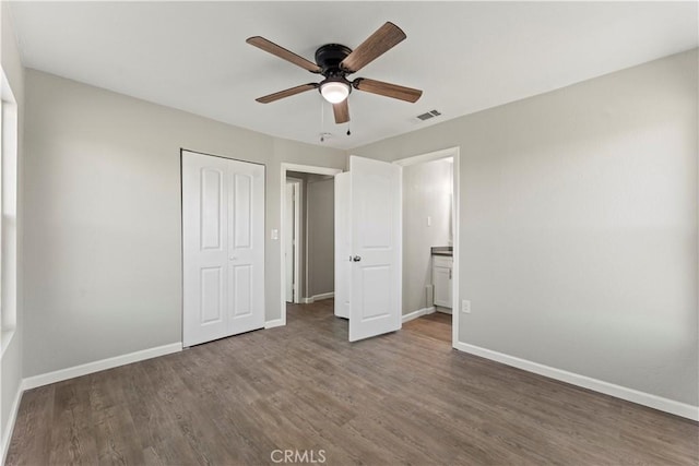 unfurnished bedroom featuring ceiling fan, dark hardwood / wood-style flooring, and a closet