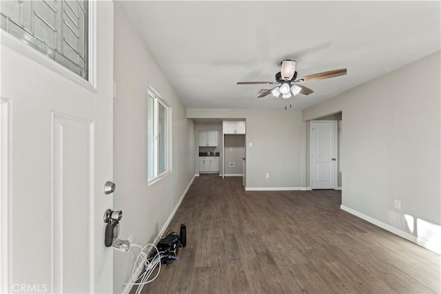 unfurnished living room with dark hardwood / wood-style floors and ceiling fan