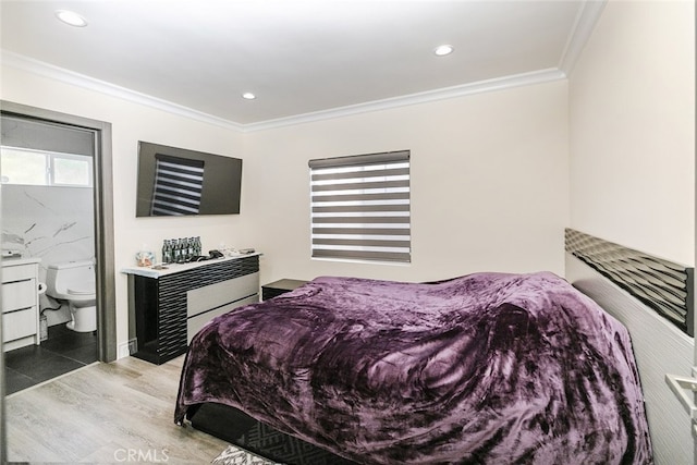 bedroom with crown molding, ensuite bath, and light wood-type flooring