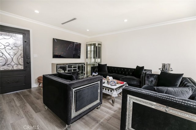 living room with hardwood / wood-style flooring and crown molding