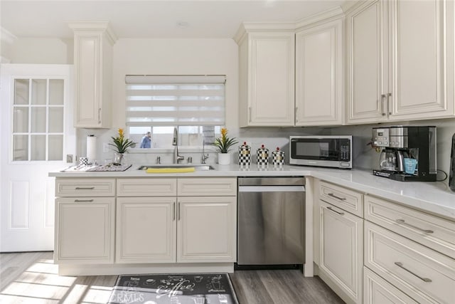 kitchen featuring appliances with stainless steel finishes, dark hardwood / wood-style floors, light stone countertops, and sink