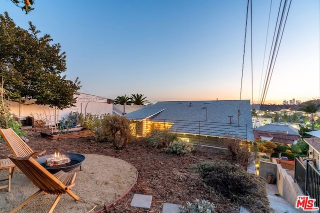 yard at dusk featuring an outdoor fire pit