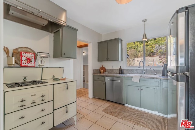 kitchen with sink, light tile patterned floors, appliances with stainless steel finishes, hanging light fixtures, and exhaust hood