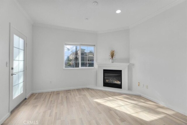 unfurnished living room with crown molding and light wood-type flooring