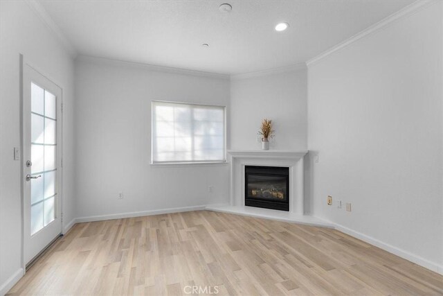 unfurnished living room featuring crown molding and light hardwood / wood-style floors