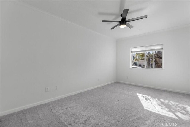 carpeted spare room featuring ornamental molding and ceiling fan