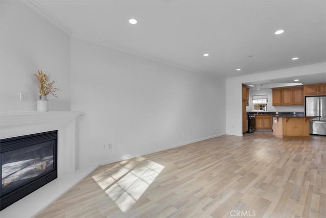 unfurnished living room with ornamental molding and light hardwood / wood-style flooring