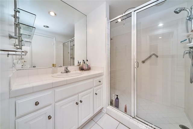 bathroom with vanity, an enclosed shower, and tile patterned flooring