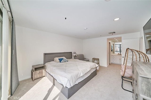 carpeted bedroom featuring ensuite bath