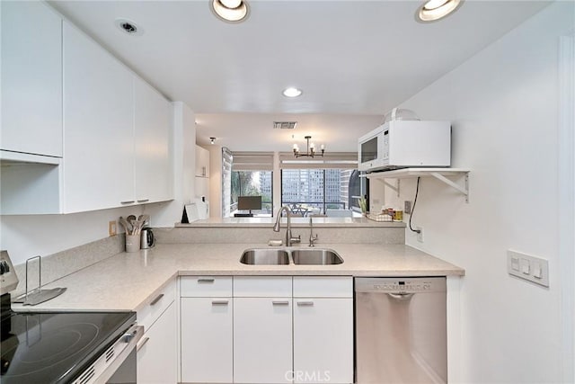 kitchen featuring white cabinetry, sink, a chandelier, and appliances with stainless steel finishes