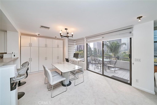 dining area featuring light carpet and a chandelier