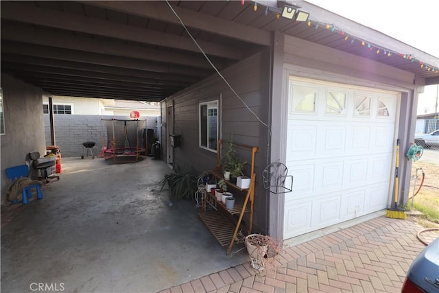 view of side of home with a garage and a trampoline