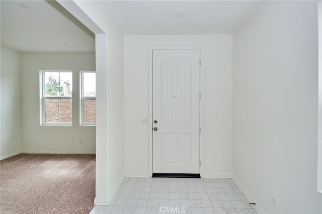 foyer entrance featuring light carpet