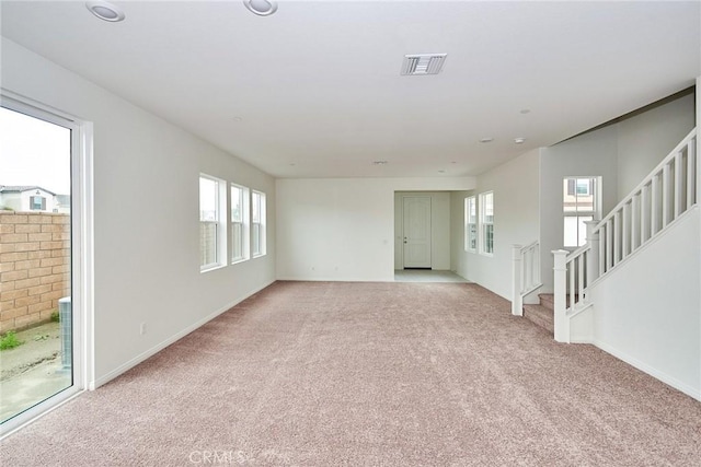 unfurnished living room with light colored carpet