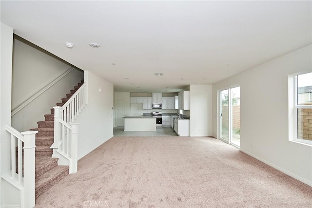 unfurnished living room with light colored carpet