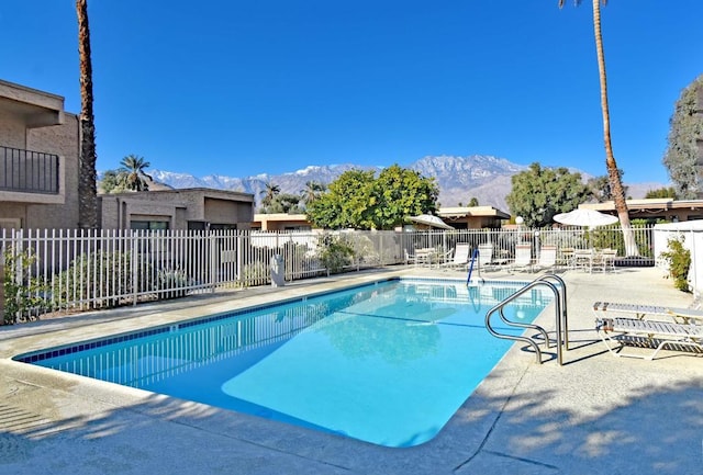 view of swimming pool with a mountain view and a patio