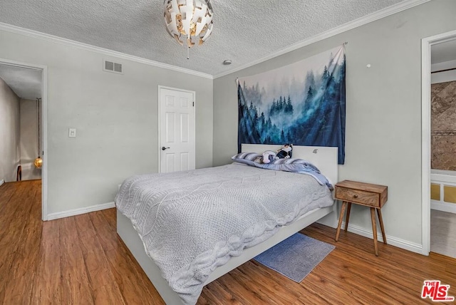 bedroom with ornamental molding, hardwood / wood-style floors, and a textured ceiling