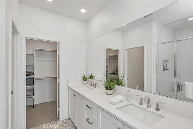 bathroom with vanity and a shower with door