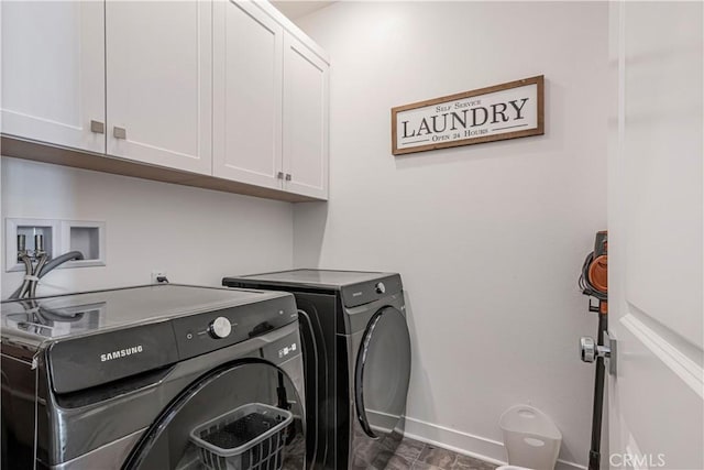 clothes washing area featuring cabinets and independent washer and dryer