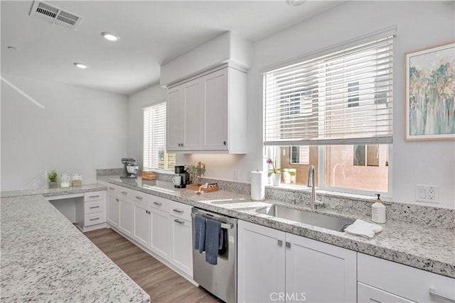 kitchen featuring white cabinetry, light stone countertops, and stainless steel dishwasher