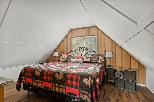 bedroom featuring wood finished floors, vaulted ceiling, and wood walls